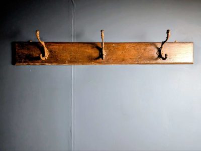 Three huge cast Antique French hooks on oak panel