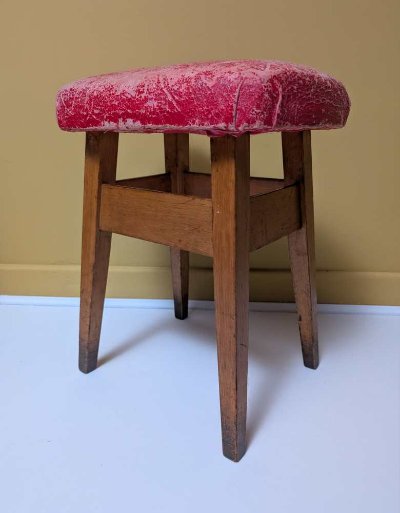 Vintage beech stool with worn, red cushioned seat - Image 2
