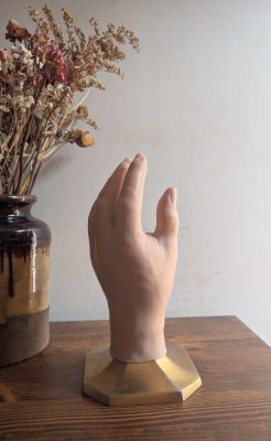 Male prosthetic hand on golden plinth